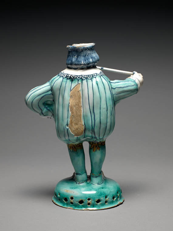 An image of Figure of Nobody. Brislington Pottery, possibly, London. Buff earthenware, moulded in parts, tin-glazed, and painted in blue, pale turquoise-green, yellow, and orange, height, whole, 23.3 cm, diameter, base, 10.6 cm, dated 1675. Anthropomorphic vessel.