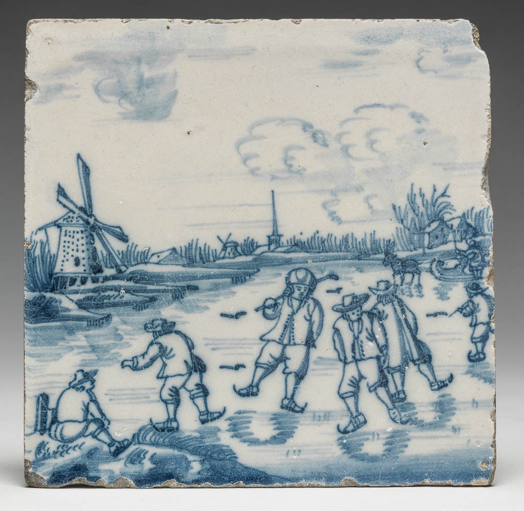 An image of Earthenware, tin-glazed white on the upper surface and painted in blue. A skating scene. A group of men skating on a frozen canal. In the background, two windmills, a church and houses. There is a hole in the top left and in the lower right corner. Height 12.6 cm, width 12.6 cm, depth 0.9 cm, circa 1700-1800. Netherlands.