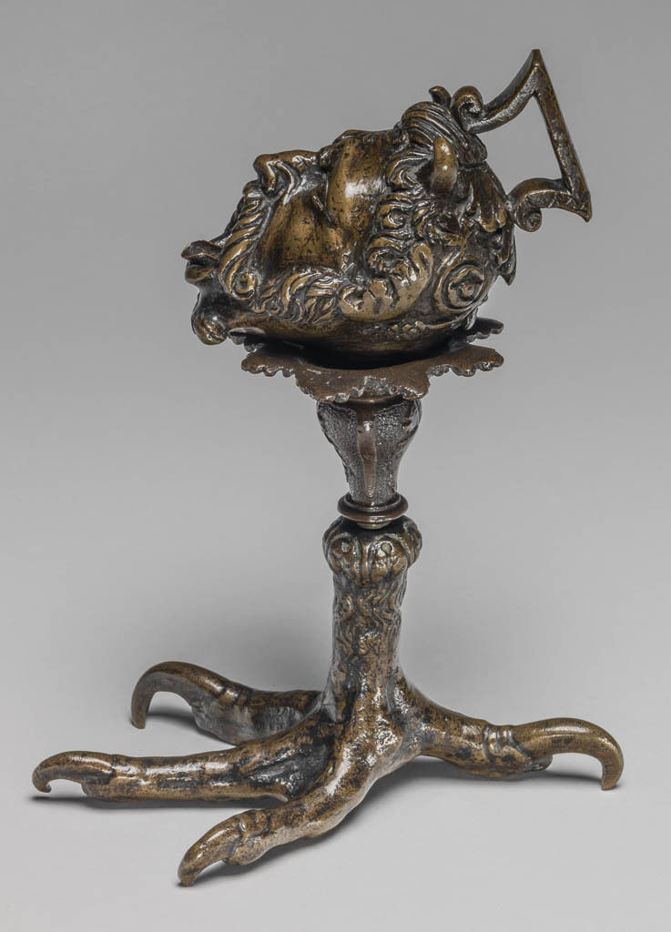 An image of Sculpture/Oil lamp. Cast in the form of a satyr's head on a separately cast claw-foot stand. Severo di Ravenna (workshop (Italian, act.1496, d. before 1543). Production Place: Padua. Bronze, cast, heght (whole) 20.2 cm, after 1496. Renaissance. Production Notes: The stand may not be original.