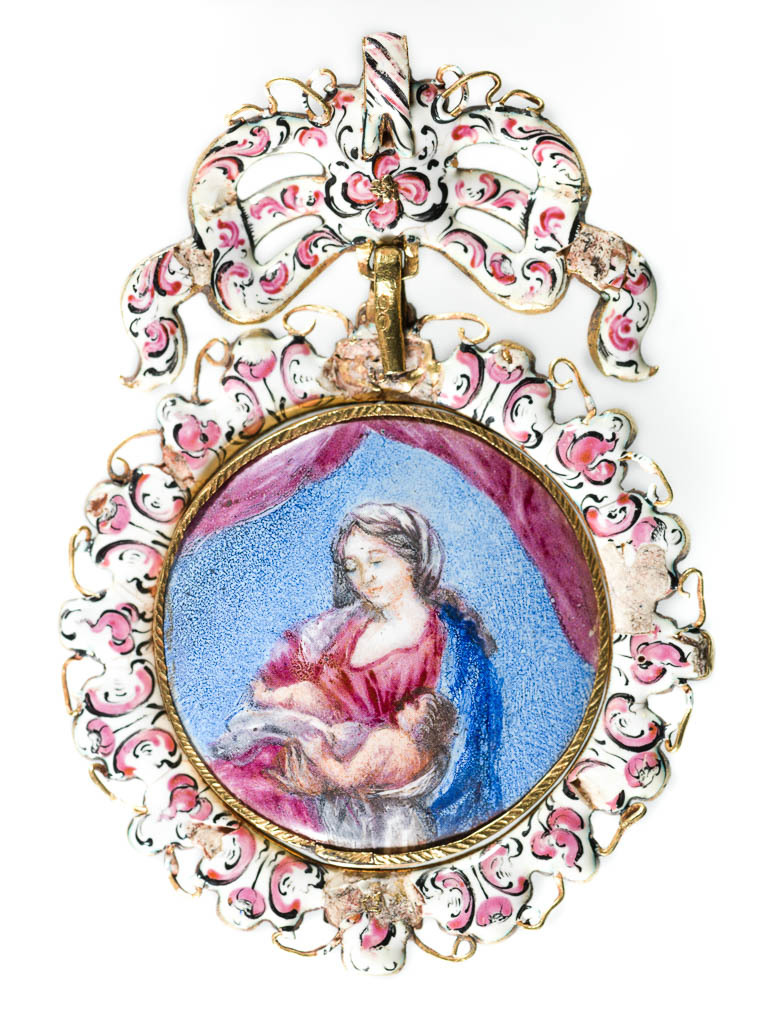 An image of Pendant/Jewellery. Gold, set with emeralds and two diamonds and a carved mother-of-pearl figure of Christ on a background of gold, engraved and enamelled in translucent green (basse-taille enamelling). The back enamelled in opaque white, pink and black and set with an enamelled plaque in blue pink and grey-black of the virgin and child. Circular with a bow at the top. Gold, basse taille enamelling, emerald decoration, mother-of-pearl carving, height, whole, 7.8 cm, width, whole, 5.4 cm, circa 1600- 1700. Spanish.