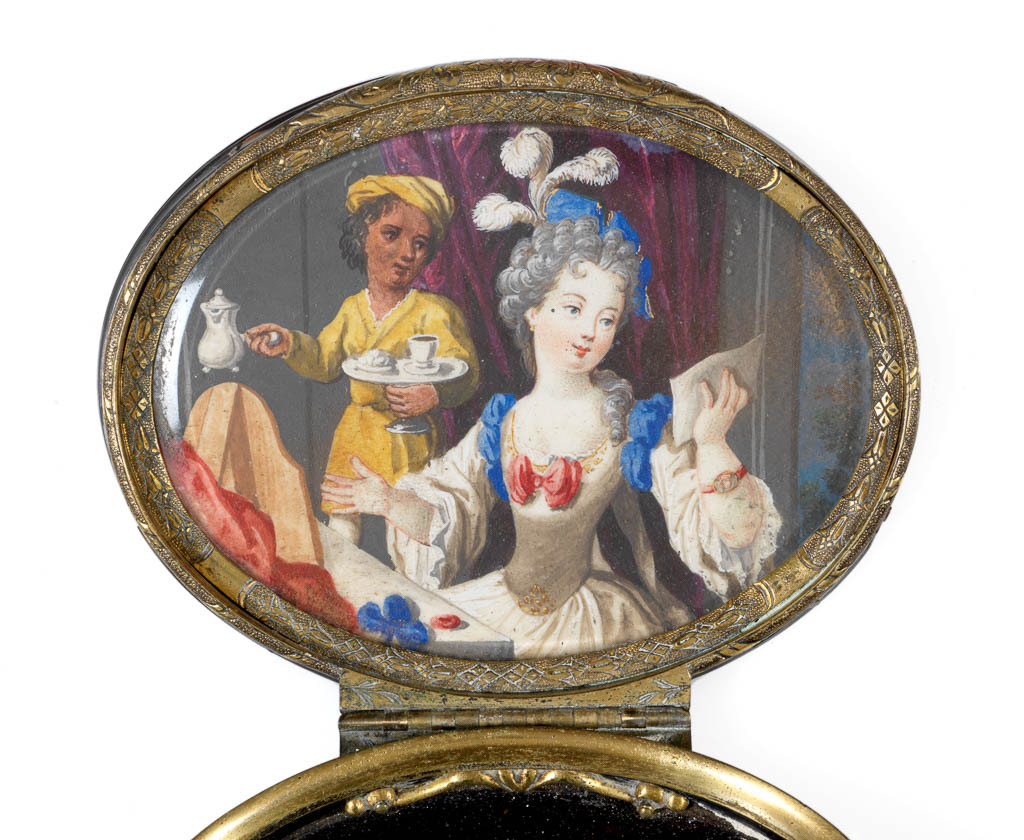 An image of Snuff box/Objets de vertu. A lady at her dressing table. Unknown maker. Tortoise shell with chased gilt metal mounts, inlaid gold piqué point work and a painted polychrome vignette in bodycolour, probably on card, under glass. Oval with straight sides with projecting edges and a projecting hinge. The top of the lid is decorated with a flowering tree, rocks, plants and a dragonfly. The base is decorated with a simpler image of a plant, cloud and dragonfly. The interior of the lid is painted with a lady seated before her dressing table and mirror; she reads a letter whilst attended by a coloured servant bringing chocolate or coffee. The thumbpiece and mount of the lid are chased with stylized foliage and flower heads. Height 1.6 cm, length 8.0 cm, width 6.5 cm, 1730-1760. Rococo. The box may be of earlier manufacture than the painting in the lid.