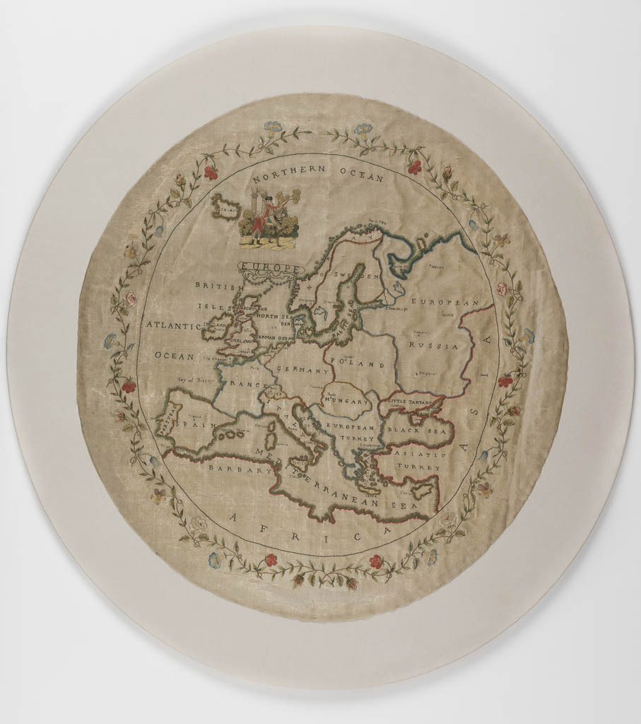 An image of Map Sampler. The map depicts the European territories, and the edges of Asia and Africa. Most countries or regions have their names embroidered inside them, as have the seas and oceans. In the right corner a small pictorial piece of embroidery depicts two men, one on a horse the other standing next to it, in front of a classic background. The map is enclosed by a meandering floral border. Oval silk map sampler with a linen backing, embroidered with polychrome silks through both layers in back and stem stitch, with French knots and painted details on the figures. The edges are raw. Length, max, 52.5 cm, width, max, 52.5 cm, circa 1770-circa 1799. English.