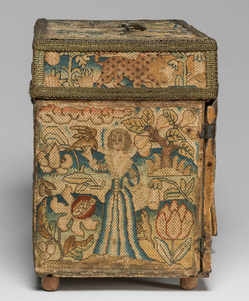 An image of Textiles. Casket with embroidered panels. Outside covered with linen, polychrome silk embroidery in rococo, tent, back, and couching stitches. Depicting the five senses: on the top Smell, on the doors Hearing and Sight, on the sides Touch and Taste. On the back Orpheus with his lyre.   Inside covered with white silk, polychrome silk embroidery in satin, dot and couching stitches with some silk covered wire. Depicting the elements: on the doors Fire and Air, on the lid Water and Earth. Further pastoral and hunting pictorial scenes inside front, Time with hour glass and scythe in centre of drawers. Silk, polychrome silk embroidery on a wooden base with mirror in lid. Height 23.6 cm, width 27.1 cm, depth 16.5 cm, circa 1650-1674. English.
