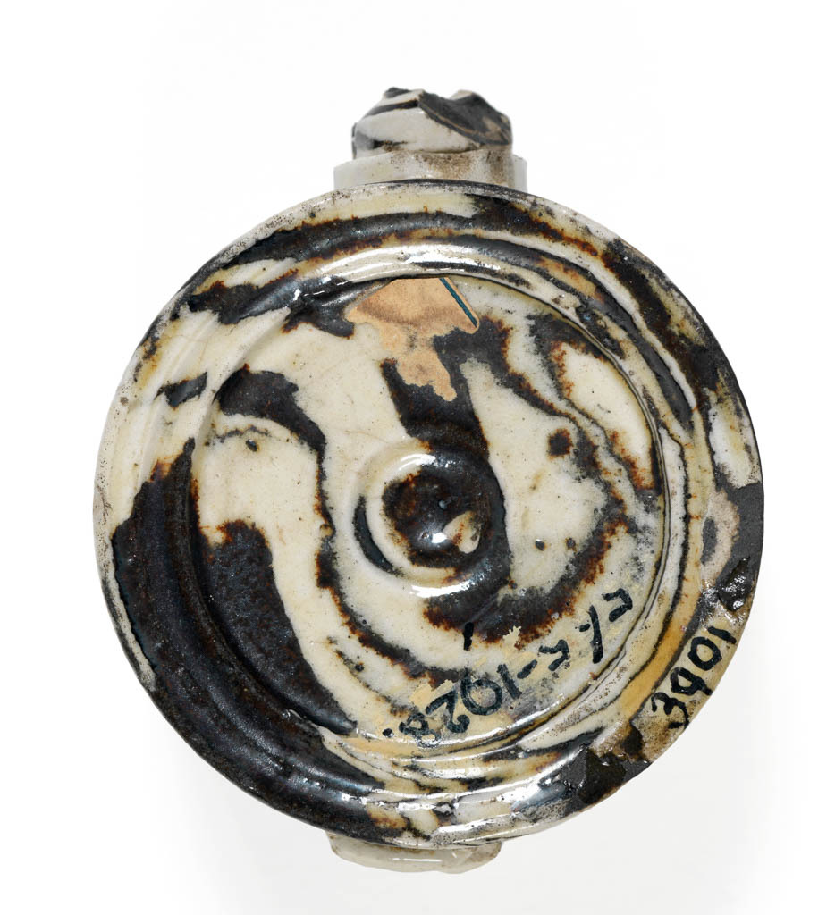 An image of Scent flask. Agate ware. Staffordshire factory. Salt-glazed dark brown and off-white agateware. Circular in the shape of a snail's shell, with on one side a small screw stopper, and on the other, a projection scored with a cross which enables the bottle to be stood up with the diameter vertical. Circa 1745-1755. Rococo.