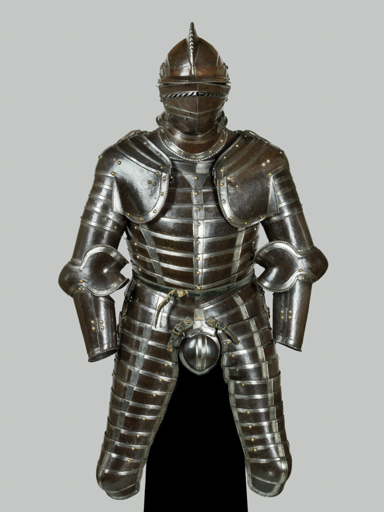An image of Composite armour. Comprising a collar, cuirass with skirt and long tassets, codpiece, pair of pauldrons and burgonet and buffe. Steel, hammered, shaped, riveted, hinged, with incised decoration and recessed borders, with brass and iron rivets and buckles. Height 134 cm, width 76 cm, depth 47 cm, c. 1530-1560. European, mainly South German.