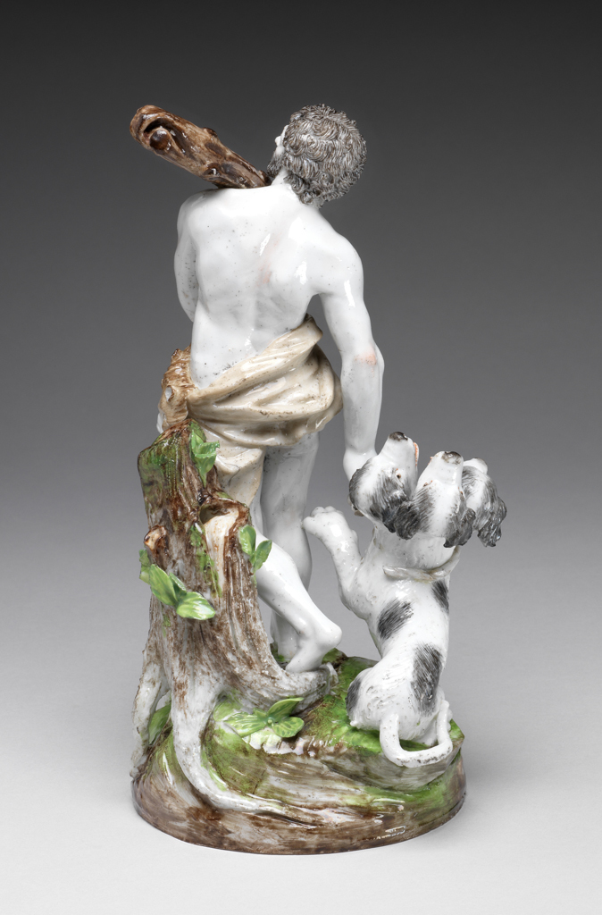 An image of Figure Group. Hercules and Cerberus. Le Nove Porcelain Factory, The Veneto, Le Nove. A brown lion skin and mask is draped around his hips. In his left hand he holds the lower end of a large dappled brown club which rests on his left shoulder. He holds a knotted rope in his right hand which is extended downwards. Cerberus, in the form of a friendly-looking black and white dog with three open-mouthed heads, is seated beside him. His left front paw is raised towards Hercules, and his tail is curled round and extends beyond the edge of the base. On his neck there is the remains of a rope which originally joined up with the knot held in Hercules’s hand. Hard-paste porcelain, press moulded and glazed, painted in polychrome enamels, height, whole, 21.9 cm, width, whole, 11.8 cm, width, base, 10.5 cm, circa 1785-1795. Antonibon-Parolin period.