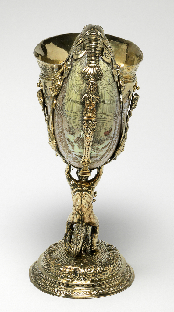 An image of Nautilus shell cup engraved with Chinese scenes and mounted with silver-gilt aquatic emblems. Nautilus shell with engraved decoration, mounted in silver-gilt, cast, embossed, chased and engraved, height (overall) 24.4 cm, width (overall) 10.8 cm, length (overall) 19 cm, c.1585-1586. London silversmith. Mannerist.