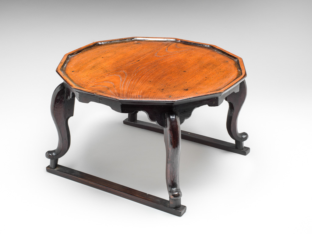 An image of Furniture. Offering table of dark brown lacquered wood, lobed shaped. Korean, age uncertain, possibly late 19th century to early 20th century. Wood, dark brown, lacquer, 1870-1930.