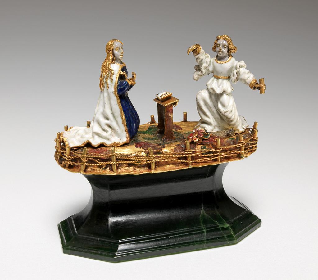 An image of Figure group. The Annunciation, part of a reliquary. Gold, enamelled en ronde bosse with opaque white, and translucent blue, red and green enamels, on a later wooden base, height 3.7 cm, width 6.7 cm, circa 1450-1500. European, possibly Burgundian. Late Medieval.