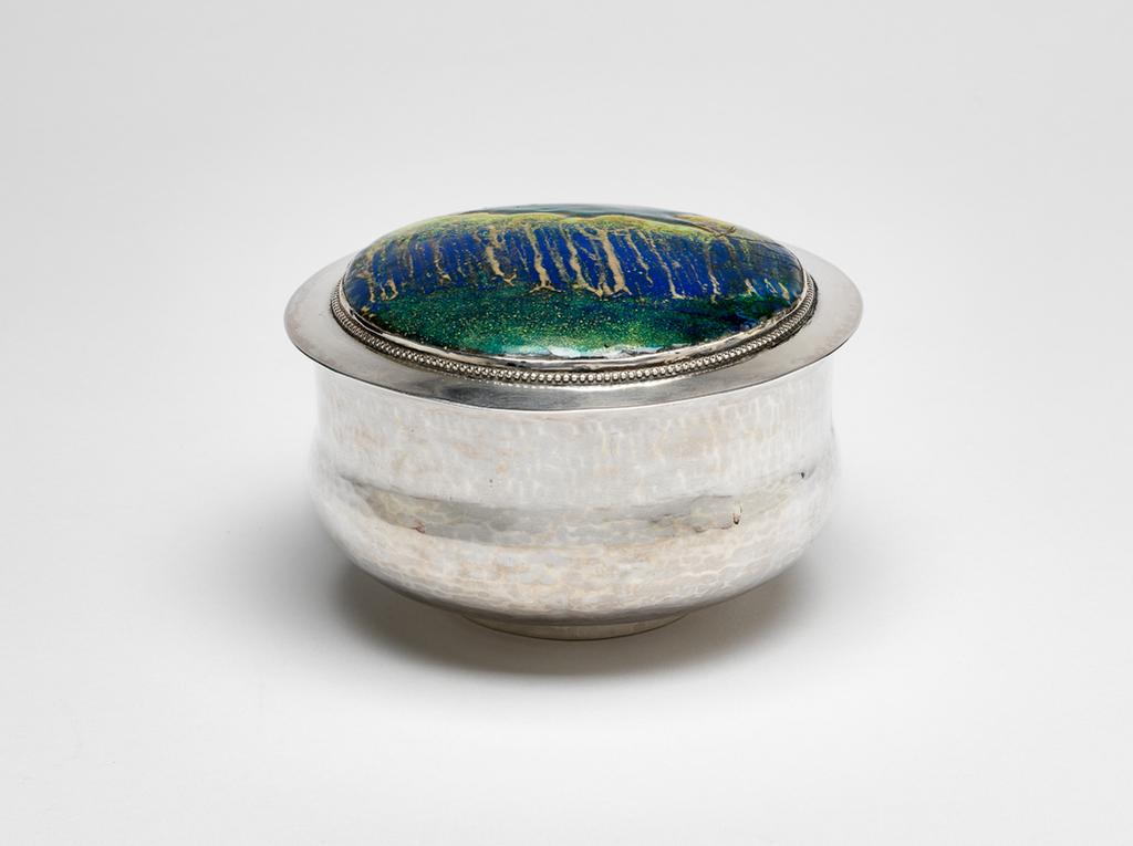 An image of Silverware. Bowl with lid. Guild and School of Handicraft, Chipping Campden. Silver bowl with lid, enamelled with a forest scene. Silver, enamel, 1902. English. Acquisition Credit: Given by the estate of the late Olive and Peter Ward.
