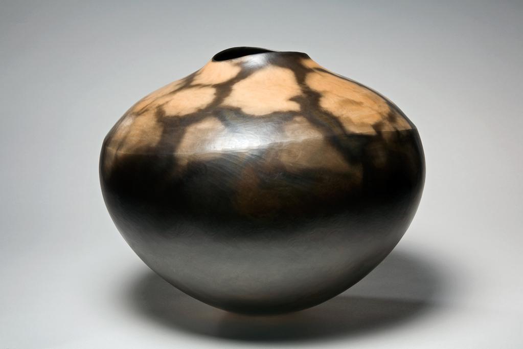 An image of Contemporary Craft. Studio Ceramics. Pot. Koch, Gabrielle (b. Lorrach, Germany, 1948). The bulbous pot stands on a narrow base. It has a very slight shoulder line, and the top cuves inwards and upwards to a narrow oval mouth. The lower part is mainly black, and the top, and part of the lower area is dappled pinkish-cream. Hand-built T-Material, coloured with black and pinkish-cream slips, burnished, saw-dust fired, waxed and polished, height, whole, 34.3 cm, diameter, whole, 43 cm, 1996. Acquisition Credit: Gift of Nicholas and Judith Goodison through the National Art Collections Fund.