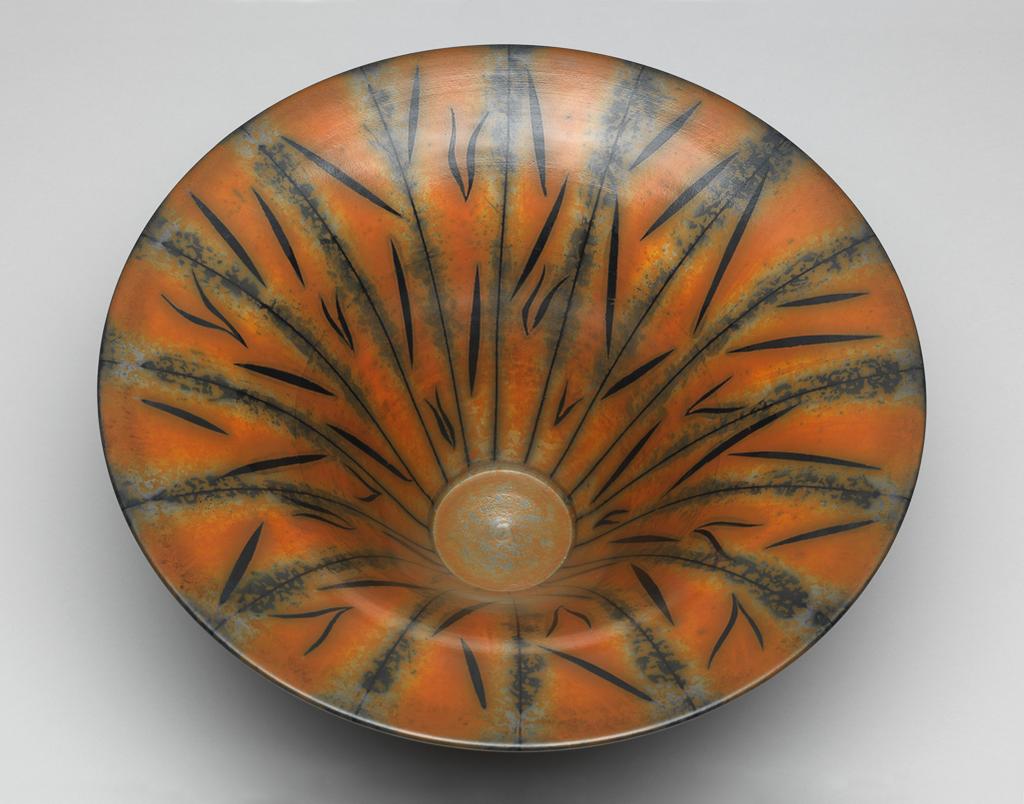 An image of Contemporary Craft. Studio Ceramics. Bowl. Ross, Duncan (British, b. 1943 India). The base is decorated with circles of alternate colours. The exterior has narrow black stripes over broader greyish-black mottled stripes separated by reddish-brown mottled stripes. The interior is decorated similarly with in addition black strokes over the reddish-brown stripes. Thrown red earthenware, coated with terra sigillata slip with inlaid and resist decoration, burnished, bisque-fired, and smoke fired, height, whole, 13.0 cm, diameter, rim, 28.3 cm, 1991. Gift of Nicholas and Judith Goodison through the National Art Collections Fund.