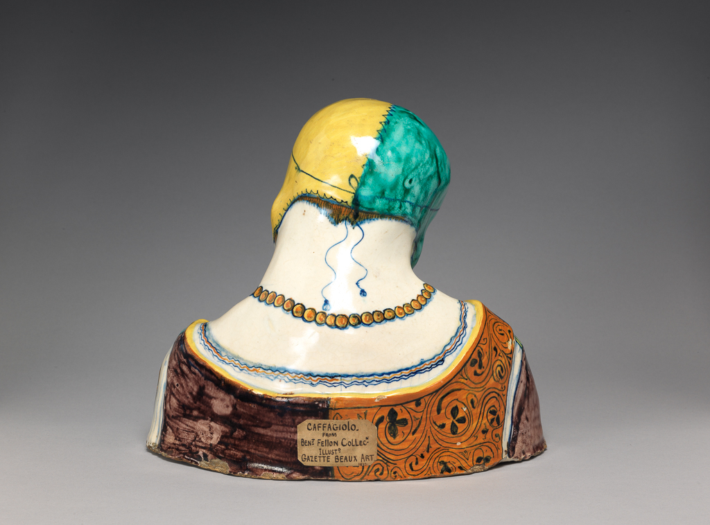 An image of Maiolica. Bust of an old woman. Production Place: Italy, Emilia-Romagna, Faenza (probably). Pale buff earthenware, tin-glazed on the exterior; underside unglazed. Painted in dark blue, green, yellow, orange, manganese-purple, and black. height, whole, 20.9 cm, width, whole, 24.0 cm, circa 1490-1510. Renaissance.
