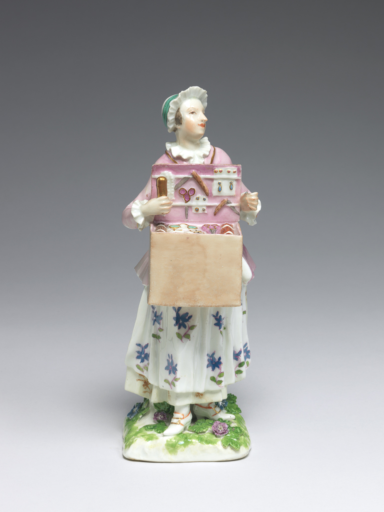 An image of A Trinket Seller. Meissen Porcelain Manufactory, Saxony. Hard-paste porcelain painted in enamels, height, whole, 18.7 cm, width, whole, 6.5 cm, circa 1745-1750.