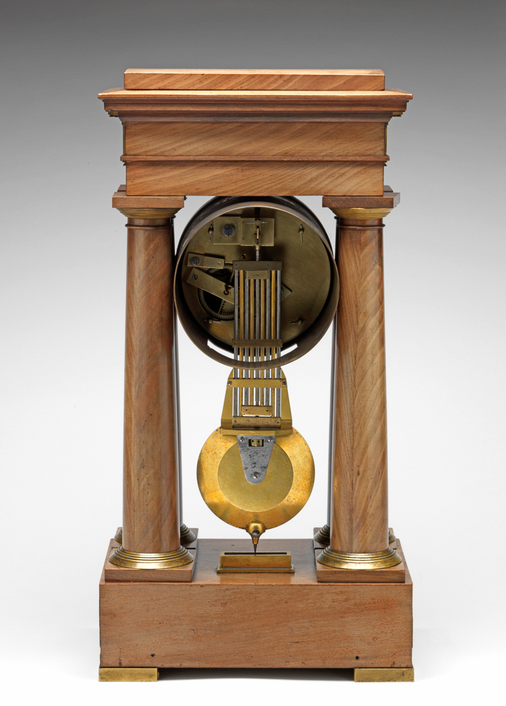 An image of Decimal clock. Destigny, Pierre Daniel, (french, apprenticed 1787, d.1855). With dials showing decimal time and duodecimal time. Dial: 4 1/2 inch diameter dial with gilt engine-turned centre and bezel. Narrow enamel chapter ring with 100 minute divisions on the inner edge each divided into halves, with arabic numerals 1 - 10 for the hours, and seconds divisions on the outer edge numbered 10, 20 - 100. Blued steel hands, plain for minutes and voided spade design for hours and sweep seconds. Small enamel dial inset above the centre with hours I - XII twice and minutes on the outer edge numbered 15, 30, 45, 60. Signed above the lower XII `Destigny A Rouen'. Moon design hour and minute hands. Movement: Timepiece movement, reputed to run for 45 days, so intended to be wound monthly. Going barrel with dead beat escapement and beat setting adjustment to crutch. Half decimal second pendulum with 9 rod grid iron compensation and massive bob. A pointer is fixed to the bottom of the bob to show the amplitude of vibration on a degree scale fixed to the case. Case: Pine carcase veneered with mahogany. In the form of a rectangular plinth with four Tuscan columns supporting an entablature and with gilt metal mounts. Height, whole, 48.3 cm, circa 1798 to circa 1805. Neoclassical. Production Note: This is a rare example of a clock showing the time in decimal units as introduced by the French Revolutionary Government in 1793.