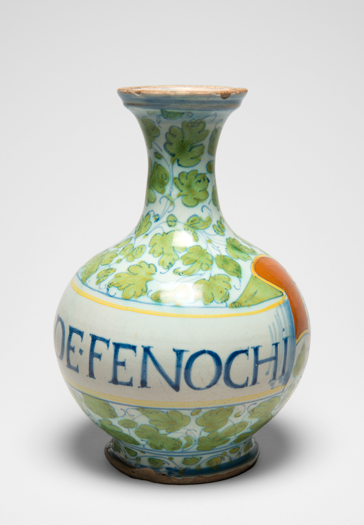 An image of Maiolica Pharmacy Bottle. Unidentified Castel Durante or Pesaro potter. On the front is a scroll inscribed in blue Roman capitals `C DE FENOCHI'. Pale buff earthenware, tin-glazed overall, the interior appearing cream. Painted in blue, yellowish-green, yellow, and orange, height 22.2 cm, diameter 15.4 cm, circa 1550-1600. Renaissance. Production Note: Probably made in Castel Durante, or in Pesaro.