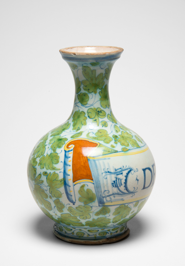 An image of Maiolica Pharmacy Bottle. Unidentified Castel Durante or Pesaro potter. On the front is a scroll inscribed in blue Roman capitals `C DE FENOCHI'. Pale buff earthenware, tin-glazed overall, the interior appearing cream. Painted in blue, yellowish-green, yellow, and orange, height 22.2 cm, diameter 15.4 cm, circa 1550-1600. Renaissance. Production Note: Probably made in Castel Durante, or in Pesaro.