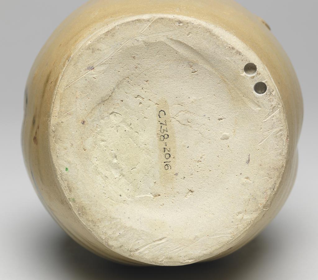 An image of Greyish white stoneware ewer. Changsha Kilns. Ovoid body with an outspreading neck, a large band loop handle, and a short octagonal spout. The body is decorated with underglaze painting of flower design in brown, just beneath the spout, and covered with yellowish green glaze. 610-907. Chinese. Tang Dynasty (618-907).