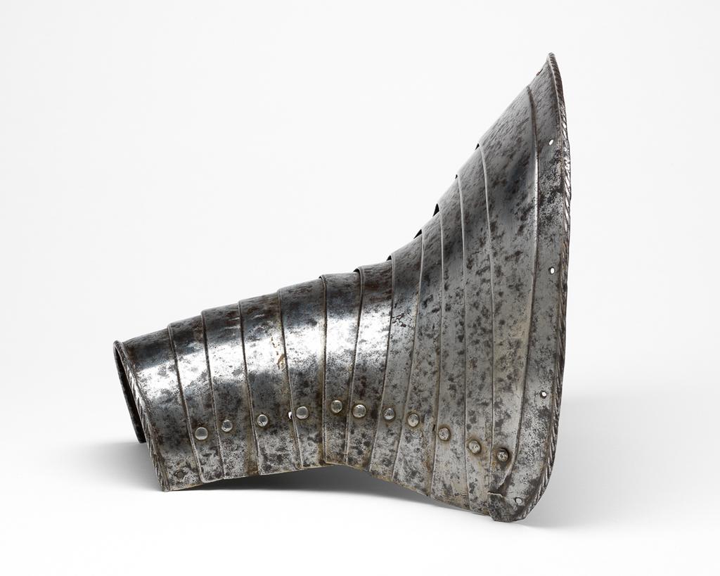 An image of Armour. Leg-defence for the right foreleg of a horse. Unknown production, Germany. Formed of twelve downward-overlapping lames curved to the front of the horse's upper foreleg and shoulder, and increasing in width to its upper end. The upper edge of the top lame is slightly convex with gently rounded corners. It has a file-roped inward turn accompanied by a recessed border containing nine holes for lining-rivets, all of which are now missing. The lower edge of the bottom lame also has a file-roped inward turn. The outer ends of the lame are each pierced with a rivet-hole that formerly served to secure a strap around the rear of the horse's leg. The first to eleventh lames have bevelled lower edges. The lames are connected to one another at their outer ends by modern, round-headed lining-rivets with internal washers that are variously square, pentagonal, hexagonal or circular. The lames were further connected to one another by a pair of internal leathers located a short distance within the sliding-rivets. The leathers were attached to each lame by single externally-flush rivets, all of which are now missing. Steel, formed of twelve downward-overlapping lames curved to the front of the horse's upper foreleg and shoulder, and increasing in width to its upper end; hammered, shaped, riveted, with a recessed border, file-roped and bevelled decoration. Height, whole, 25.6 cm, maximum, width, whole, 26.2 cm, maximum, depth, whole, 22.1 cm, maximum, weight, whole, 1.07 kg, circa 1550. Provenance: From the armoury of the Princes Radziwill, Castle of Niescwiez, Poland. Production Notes: The leg-defence originally had a `black from the hammer' finish, now cleaned to a mottled bright finish with light to heavy pitting overall. Similar leg-defences for a horse are depicted in Hans Burkmeier's Triumph of Maximilian. Forming a pair or near pair to M.9-1945.