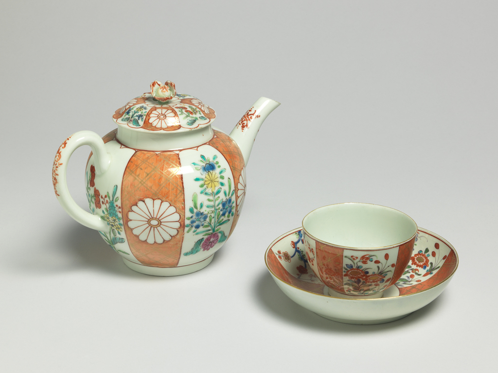 An image of Teapot and cover. Worcester Porcelain Factory. Giles, James, probably (British porcelain painter, 1718-1780, London). The globular teapot has a curved spout and ribbed loop handle, and a low footring. The slightly domed cover has a flower knob. The sides of the teapot are painted, probably in the atelier of James Giles, with a Japanese pattern, with four upright orange-ground panels with gilt trelliswork, each with a chrysanthemum head mons in reserve, separated by four flower sprays in famille-rose style. The handle and spout have a rococo motif in red. The cover is painted in en suite. Soft-paste porcelain, lead glazed, painted in orange, red, yellow, green, blue and pink enamels, and gilt, height, whole, 14.0 cm, length, whole, 19.3 cm, circa 1765-1768. Japanese Style.