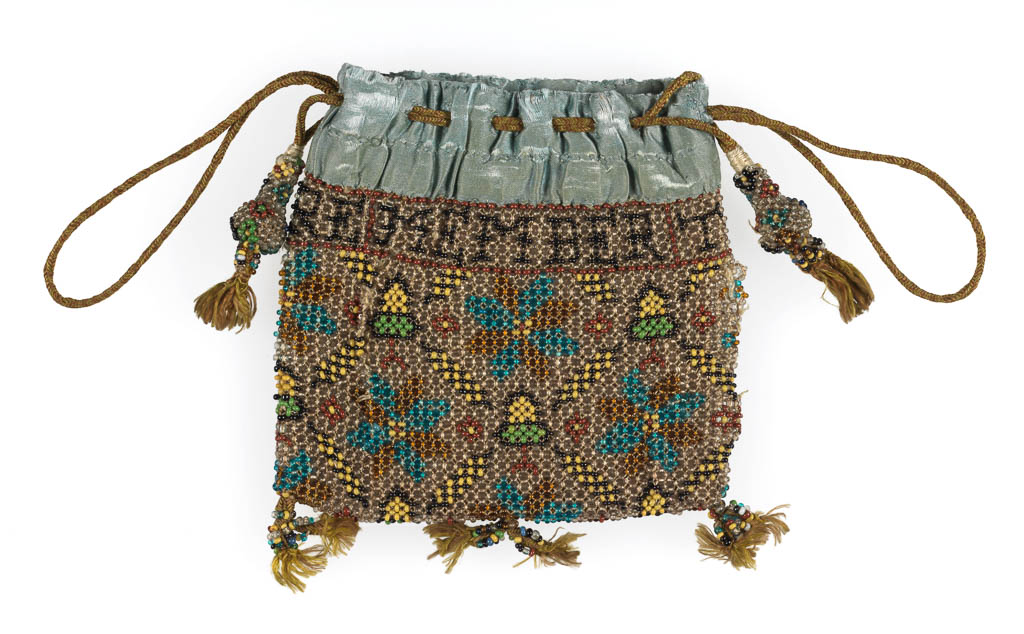 An image of Textiles. Purse. Unknown maker. Beads (opaque black, yellow, green and brick red; clear blue and gold) threaded on natural silk threads. Lined in leather, bound at top with pale blue satin. Around the top RE / MEMBER / THE / POOR / 1631. Cords for hanging and draw strings, pear-shaped beaded drops, each with two small tassels, three pairs of tassels on bottom edge. Height, whole, 5 in, width, whole, 5 in, 1631. English.