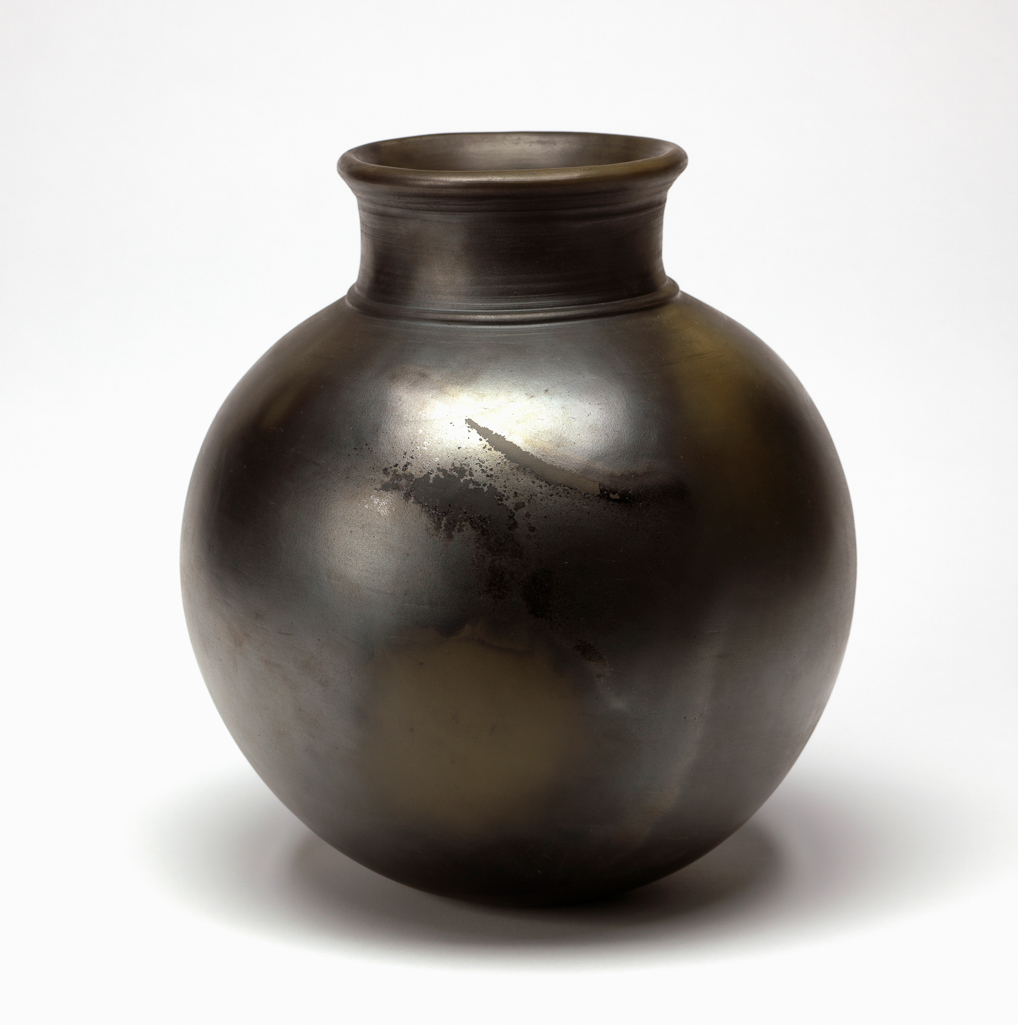An image of Studio Ceramics. Pot. Odundo, Magdalene (British, b. Nairobi, 1950). The jar is globular with a short neck and slightly everted rim. Earthenware, handbuilt with coiling, burnished, bisque-fired, and smoke-fired, height, whole, 27.5 cm, circa 1983.