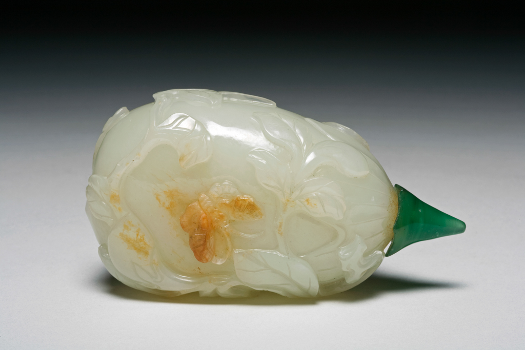 An image of Snuff bottle. Nephrite of white colour in the form of a fruit with leaves, tendrils and a butterfly in relief. Height 7.1 cm, 1760-1880.  Production Place: China.