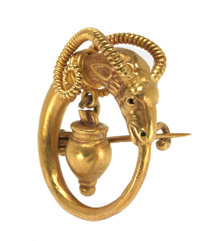 An image of Jewellery. Brooch cast in the shape of a ring with an antelope or gazelle’s head at the top, which has a vase suspended inside the ring from its collar. Castellani family, (Italian, 19th-20th centuries). Pin fastening across the back. Gold, cast, height, whole, 3.3 cm, width, whole, 3.1 cm, circa 1860-1870. Archaeological Style. Acquisition Credit: Given by Mrs J. Hull Grundy.
