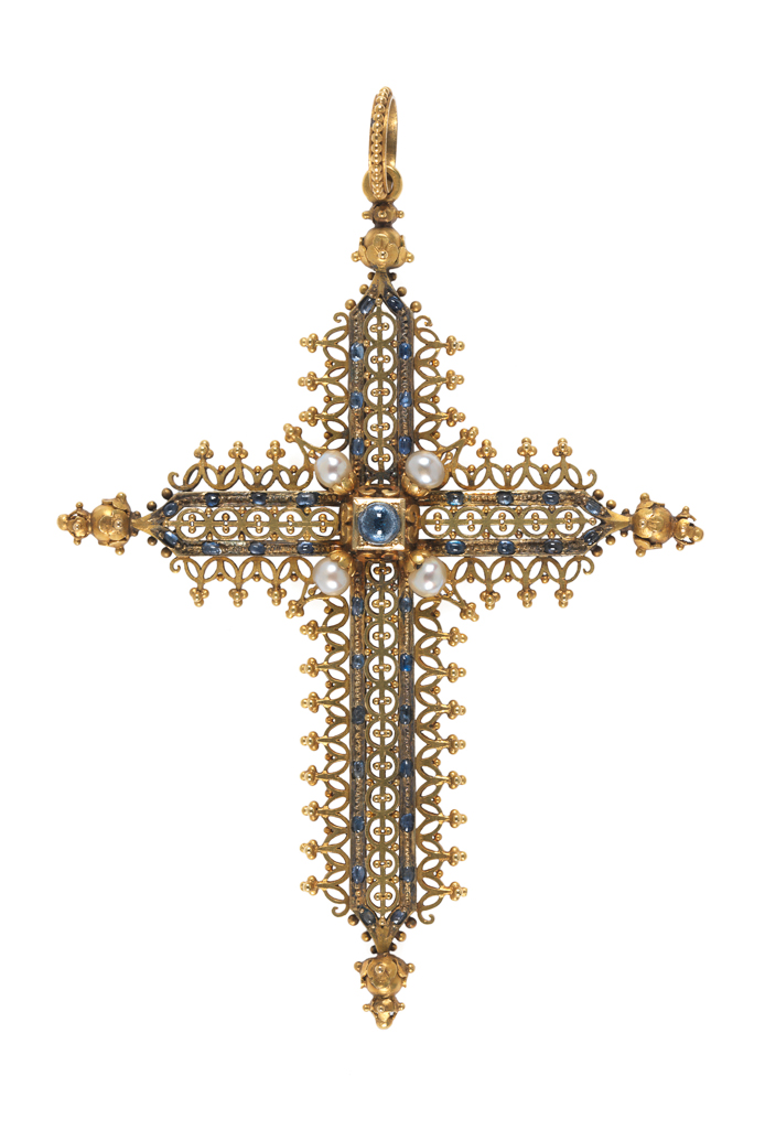 An image of Jewellery. Pendant, cross. Rinzi, Ernesto (British, 1836-1909, London). In the middle of the back, an empty square compartment under glass. At the top, a ring loop and a beaded ring for suspension. In original leather case (A). Gold openwork set with cabochon sapphires and four pearls, height, whole, 10.0 cm, width, whole, 7.5 cm, circa 1860-1865. Acquisition Credit: Given by Mrs J. Hull Grundy.