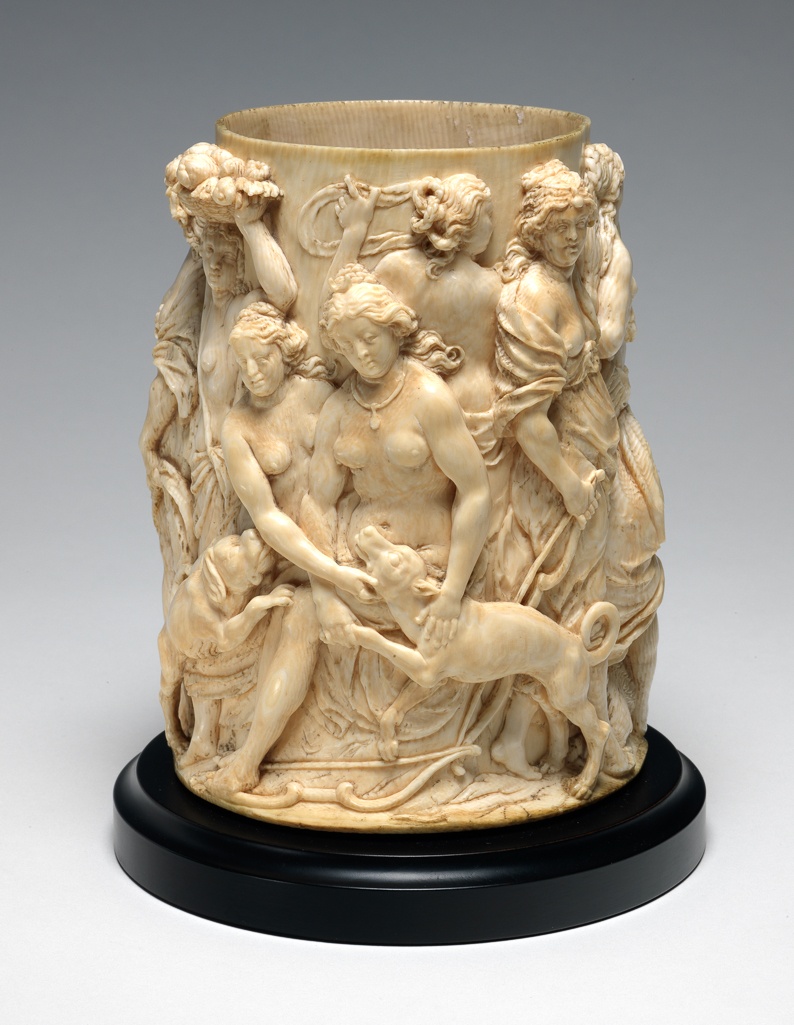 An image of Sculpture / Tankard Body. Diana with Nymphs and Hounds returning from the Hunt. Unknown Maker. Ivory, carved in high relief on the exterior, height, ivory, 15.6 cm, diameter, rim, 9.7 cm, diameter, base, 12.0 cm, circa 1660. Flemish. Baroque.
