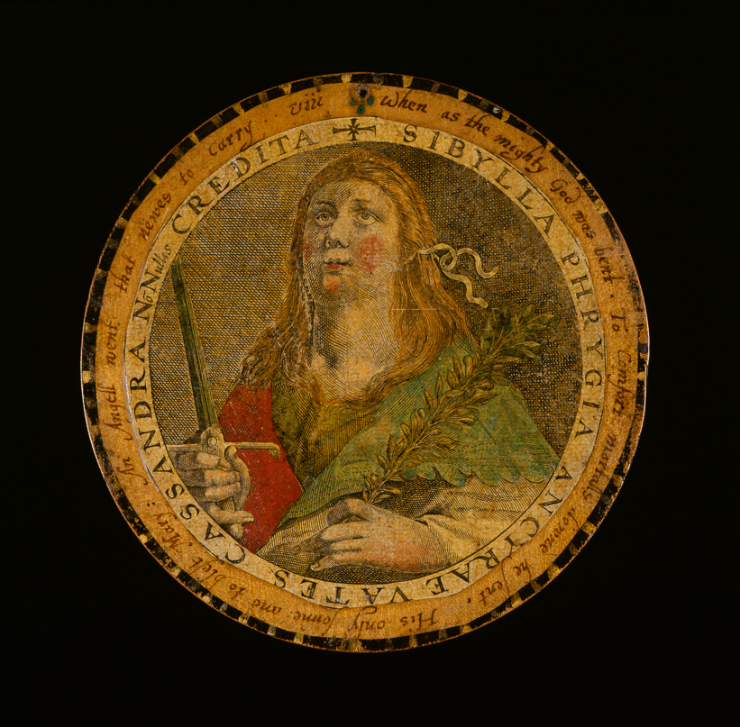 An image of Roundel or trencher. One of twelve wooden roundels, with an applied print of the Phrygian Sibyl. Hand-coloured, and inscribed in ink, diameter 13.5 cm, circa 1601-1625. Part of M.5.1-13 & A-1920: Box containing twelve roundels or trenchers. Unknown maker, after Passe, Crispijn I de, printmaker (Flemish, 1564-1637). Circular box and cover of turned wood, containing twelve roundels. Each decorated with an applied hand-coloured engraving of a Sibyl, surrounded by a hand-written English inscription. Height, box, 6.7 cm, diameter, box, 17.1 cm, diameter, roundels, 13.7 cm, circa 1601 to circa 1625.