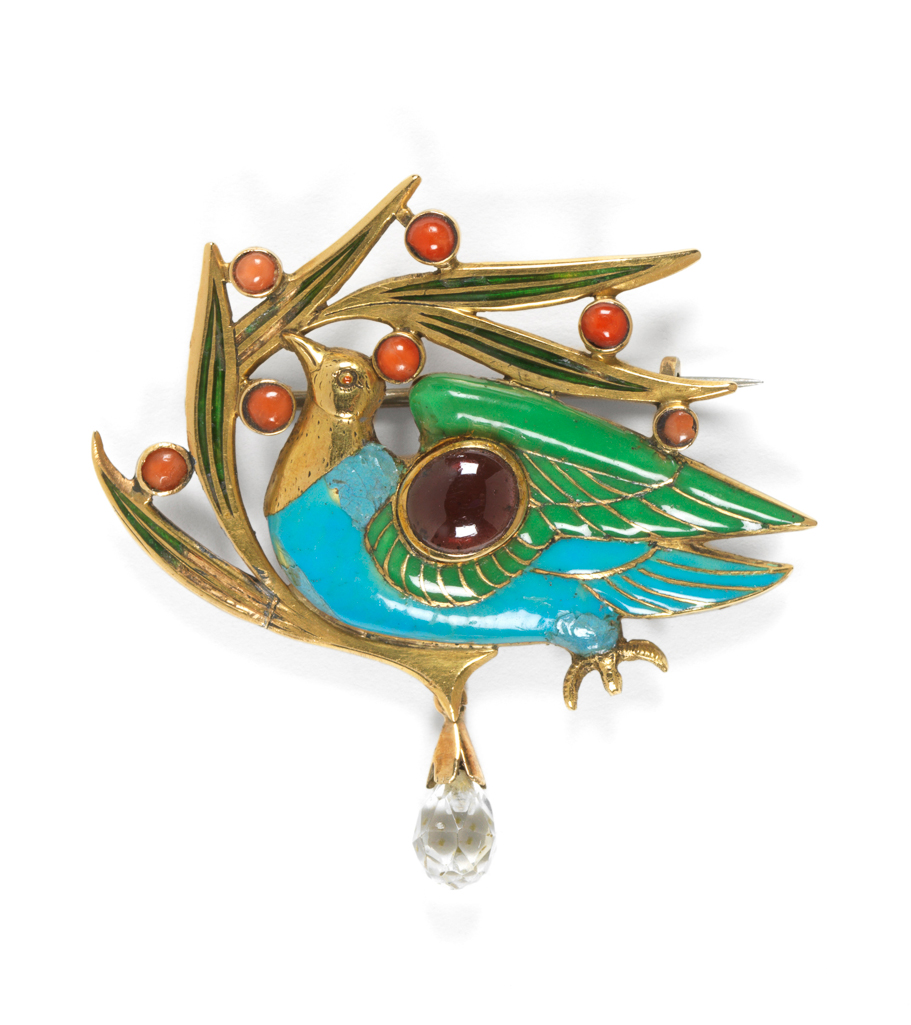 An image of Jewellery. Brooch. The Blue Bird Brooch. Carlo & Arthur Giuliano (maker). Ricketts, Charles de Sousy (designer) (British, 1866-1931). Gold, enamelled in translucent green, and opaque turquoise and green, and set with a cabochon garnet, and seven cabochon corals. In the shape of a bird on berried foliage, with a pin fastening across the back. The bird's eye is a cabochon garnet, and the berries are cabochon corals. Height (whole) 4.7 cm, width (whole) 4.8 cm, 1899.