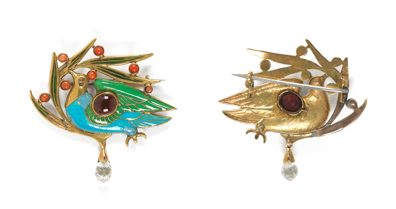 An image of Jewellery. Brooch. The Blue Bird Brooch. Carlo & Arthur Giuliano (maker). Ricketts, Charles de Sousy (designer) (British, 1866-1931). Gold, enamelled in translucent green, and opaque turquoise and green, and set with a cabochon garnet, and seven cabochon corals. In the shape of a bird on berried foliage, with a pin fastening across the back. The bird's eye is a cabochon garnet, and the berries are cabochon corals. Height (whole) 4.7 cm, width (whole) 4.8 cm, 1899.