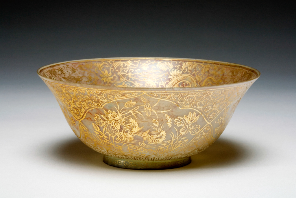 An image of Bowl. Pale celadon jade bowls, the exteriors with four cartouches, gilded with long tailed birds, pheasants and mandarin ducks among flowers, inside gilded with dragons and foliage. The interior of the footring decorated with acanthus leaves. Nephrite, height 6.1 cm, diameter 14.9 cm 1700-1800. Chinese.