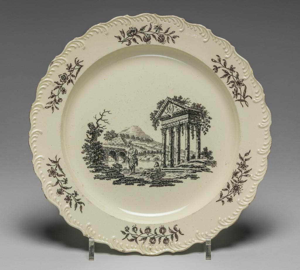 An image of Plate. Corinthian Ruins. Wedgwood, Josiah (English potter, 1730-1795). Green, Guy, printer (British ceramist, act.1756-1799). This design was known as Corinthian Ruins, but was derived from plate 1 in Robert Sayer's, The Ruins of Athens. Circular with featheredge, sloping rim, shallow curved sides, and flat centre. Decorated in the middle with Bridge over the River Ilissus and the Temple of Pola in Istria, and on the rim, with six floral sprays. Cream-coloured earthenware (Queen's ware), moulded, lead-glazed, and printed onglaze in black, height, whole, 2.3 cm, width, whole, 24.3 cm, circa 1770-1775. Rococo.