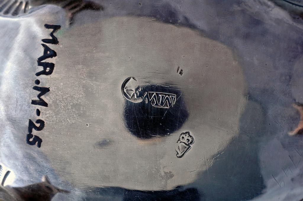 An image of Sauce Boat. West, Matthew, silversmith, probably, Ireland, Dublin. Oval with punched bead edged border; the sides embossed and chased with flowers and foliage on a matted ground (later decorated); a vacant cartouche under the lip; standing on three cast scroll legs with hoof feet; with leaf-capped double scroll handle. Silver, height, to top of handle, 9.3 cm, width, lip to handle, 15.3 cm, weight, overall, 120 g, circa 1770. Rococo.