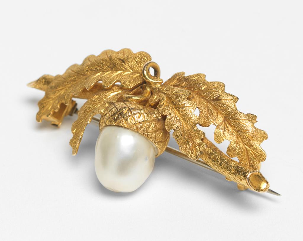 An image of Jewellery. Brooch. Giuliano, Federico, London. In the shape of a twig bearing four leaves and an acorn. Pin fastening across the back. Gold, engraved, matted and set with a pearl, height, whole, 2.9 cm, width, whole, 5.9 cm, circa 1876-1903. Acquisition Credit: Given by Mrs J. Hull Grundy.
