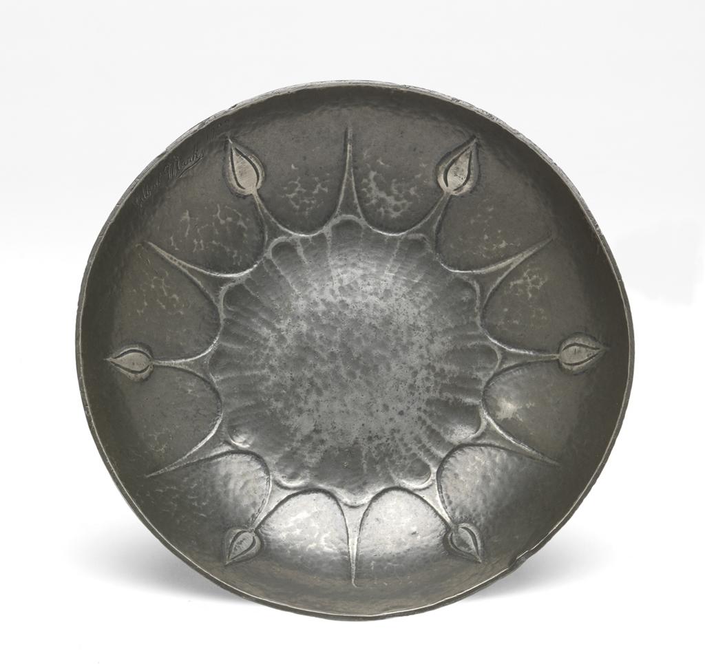 An image of Ashtray. Marks, Gilbert Leigh (British, 1861-1905). Pewter with lightly hammered surface, embossed with laternating buds and points radiating from a flower-shaped outlined in the middle. Circular with curved sides. Height, 2.2 cm, width, 11.9 cm, 1900. Arts and Crafts. Victorian. Acquisition Credit: Given by Miss Ellen Bicknell.