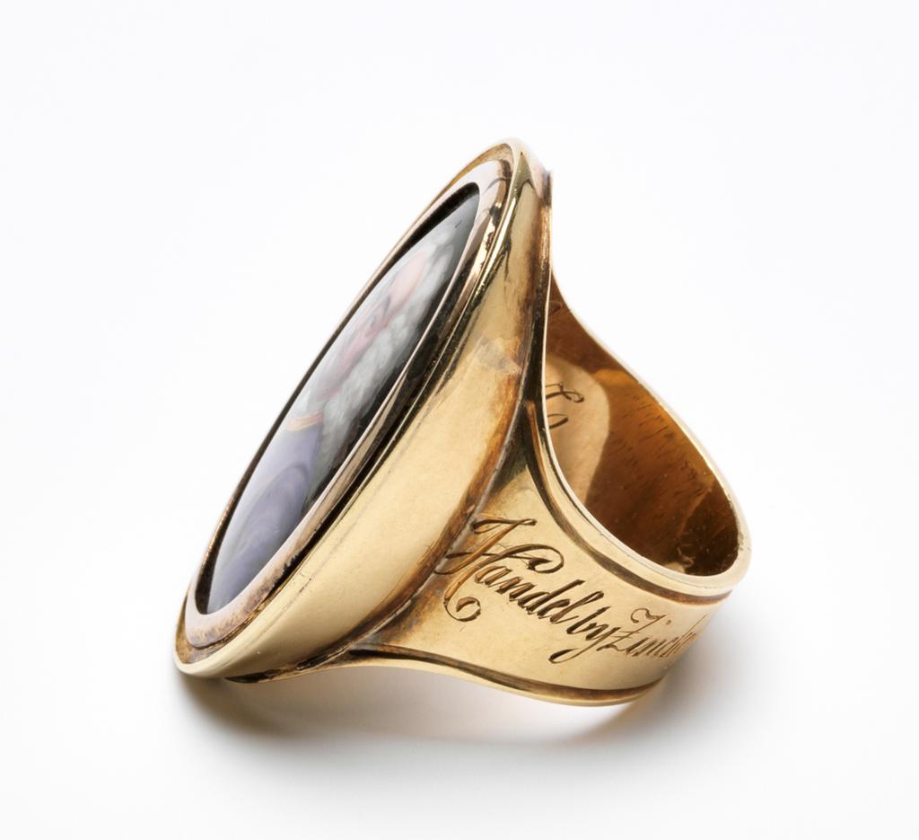 An image of Jewellery. Ring with portrait of George Frideric Handel (1685-1759). Craft, William Hopkins (British, op.1774-, d.1805). Gold, the bezel set with an enamel miniature painting of Handel. The ring band is engraved 'Handel by Zincke from the Lumsden Propert/Sale'; and inside ring, 'Presented to/Dr Whitfield by/Dr Hague, Camb/commencement/July 1819'. Late 18th century. Production Note: The miniature was formerly attributed to Christian Friedrich Zincke. The miniature was taken from the portrait of Handel by Hudson now in the National Portrait Gallery (No. 3970), but the costume was changed.