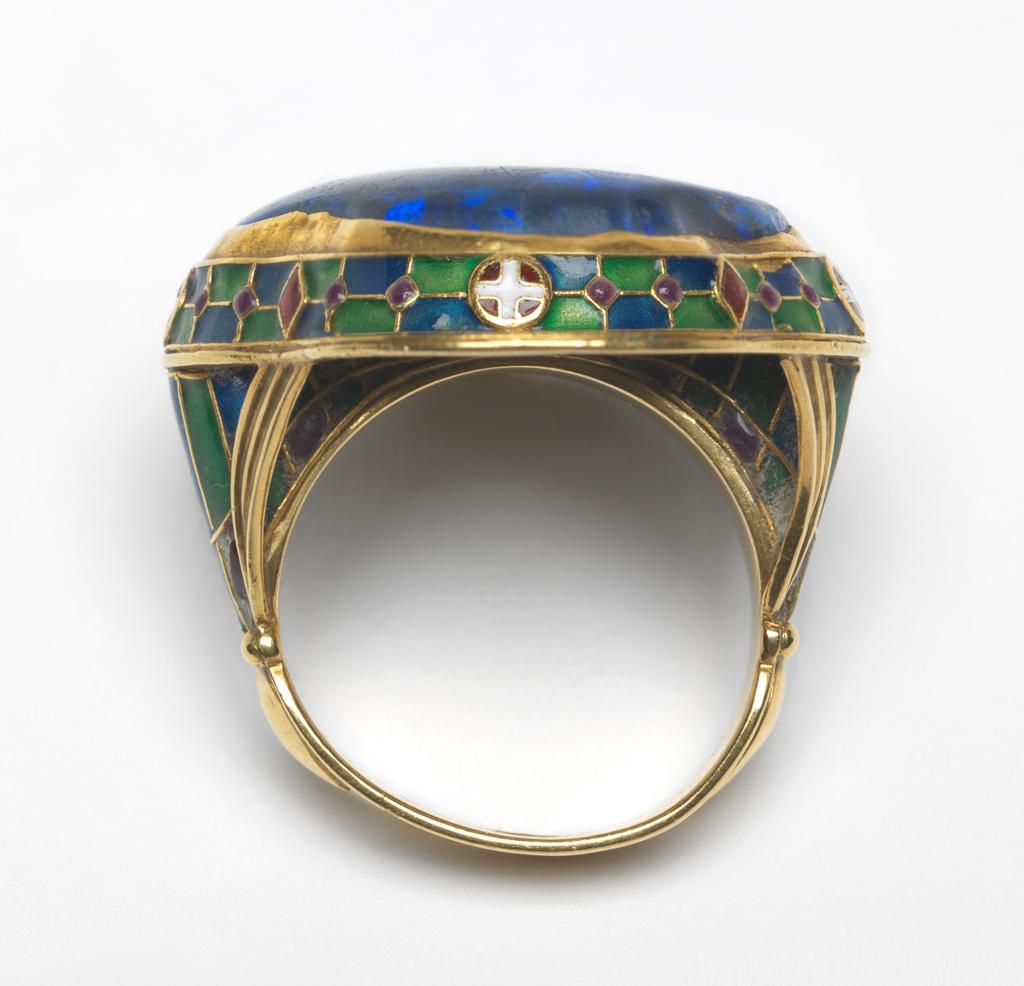 An image of Jewellery. Ring.Wilson, Henry, designer (British, 1864-1934). Gold, set with a black opal, and enamelled round the edge of the bezel and on the shoulders, length, bezel, 3 cm, diameter, whole, 2 cm, early 20th century. London.