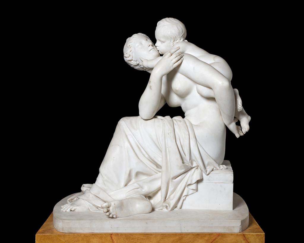An image of Maternal Affection. Sculpture/figure group. Baily, Edward Hodges (British, 1788-1867). Seated mother and child on a rectangular base with rounded ends. The mother sits on a rectangular chest in profile to the viewer. Her hair is dressed in 'Grecian' style. The lower part of her body is draped and the upper part is nude. Her left leg is forward, and her right foot tucked under it so that its sole faces the viewer. The child rests on the left side of her back, snuggling against her, and kissing her left cheek, while touching her right with his left hand. She holds her left arm out behind her to support the child's right foot, and turns the upper part of her body to the front, leaning her right elbow on her left thigh, and raising her hand towards the child. White marble, carved in the round, height, whole, 91.5 cm, 1841. Production Note: Baily exhibited a plaster of 'Affection etc.' at the Royal Academy in 1823 and in 1837 a 'Group, Maternal Affection', no. 1179.