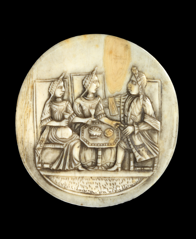 An image of Sculpture / Medallion. Circular Medallion with two ladies and a gentleman seated in high-backed chairs around an octagonal table with pedestal foot. The lady on the left holds a wine glass in her left hand and a bottle in her right. Unknown Maker. Ivory carved in low relief. circa 1700-1730. European.