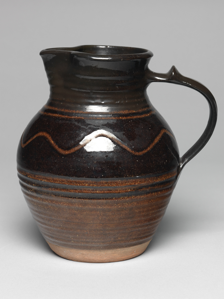 An image of Studio Ceramics. Slipware jug, light and dark brown with combed decoration. Cardew, Michael (British, 1901-1983). Earthenware, glazed, slip-coated, possibly made in the 1930s. Acquisition: Dr John Shakeshaft Bequest.