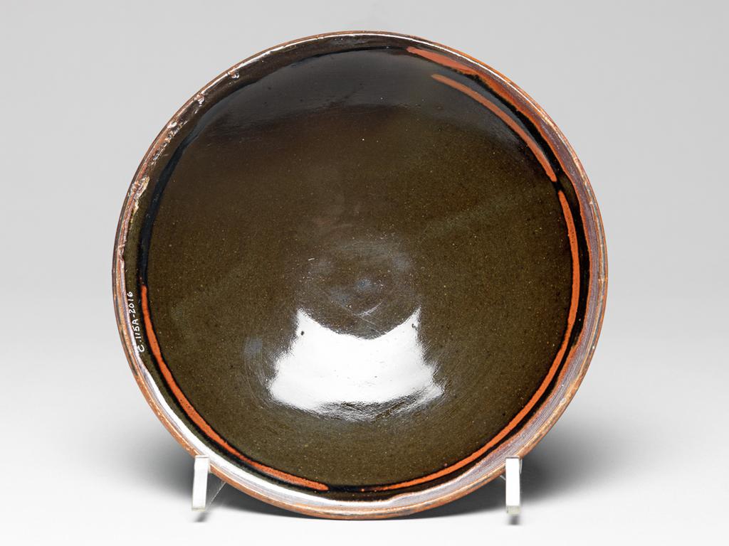 An image of Studio Ceramics. Stoneware footed food bowl, with a cover that is also usable as a bowl. Cardew, Michael (British, 1901-1983). Lustrous dark brown/bronze glaze with light brown decoration, 1946-1947. Production Place: Present day Ghana, formerly the Gold Coast. Acquisition: Dr John Shakeshaft Bequest.