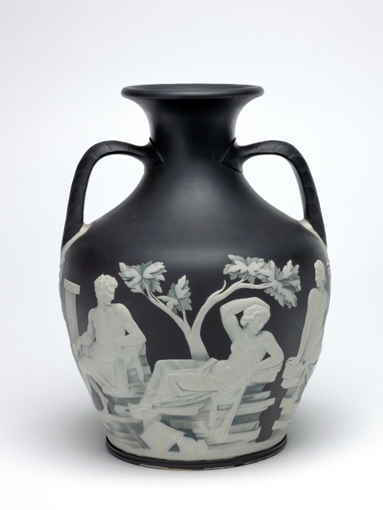 An image of Erasmus Darwin's Wedgwood Copy of the Portland Vase. Wedgwood, Josiah (English potter 1730-1795). Portland Vase copy, blue-black jasperware with applied white reliefs; on the sides classical scenes; on the base, the head of Paris. Squat ovoid body with incurved neck and everted rim, with two elbowed handles, and disk base. Decorated with two scenes separated by bearded male masks below the handles. Reading from left to right: Side 1. Two square pillars supporting an architrave, behind which is a small shrub. In front of the pillars a nude young man holding a drape behind him in his right hand, steps forward to take the arm of a partly draped woman who sits on the ground, looking back at him, and has a snake in her lap. Eros, holding a bow in his left hand and a torch in his right, flies overhead looking back to the young man. On the right, a bearded man stands in three-quarter profile to left, with his right foot on a heap of stones in front of a tree. He rests his chin on his right hand and his right elbow on his right thigh. To the right behind him there is a slender tree. Side 2. A square pillar with a capital, beside which sits a nude young man on a pile of rocks. He has a drape over his right leg, and looks to the right towards a woman, who reclines on pile of rocks in front of a tree. Her lower body is draped, and she holds a torch pointing downwards in her left hand, and has her right arm bent with the hand on her head. In front of her is a square stone with central hole and chamfered edge. On the right is a nude woman, seated on a separate pile of rocks, looking back towards the other two figures. She is partly draped, and holds a sceptre in her left hand. On the base, there is a spray of foliage above the head of a young man, in profile to right, wearing a Phrygian cap, and a cloak, and having his right forefinger to his lips. Solid blue-black jasper, thrown and turned, with applied press-moulded white reliefs, height 25.2 cm, width 19.1 cm. 1789. Neoclassi