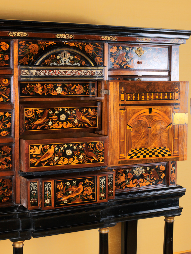 An image of Furniture. Cabinet on stand. Unknown maker. Cabinet with ten drawers, and a central cupboard flanked by corinthian columns and pilasters, decorated with marquetry of vases of flowers, birds, and flowering sprays, on an ebonized wood stand. Ebonized wood stand, height, cabinet, 31 ¼ in, width, cabinet, 54¼ in, depth, cabinet, 17 7/8 in, height, stand, 36 7/8 in ,width, stand, 52 3/4 in, depth, stand, 18¼ in, circa 1680-circa 1690. The stand is of later manufacture. Baroque. Louis XIV.