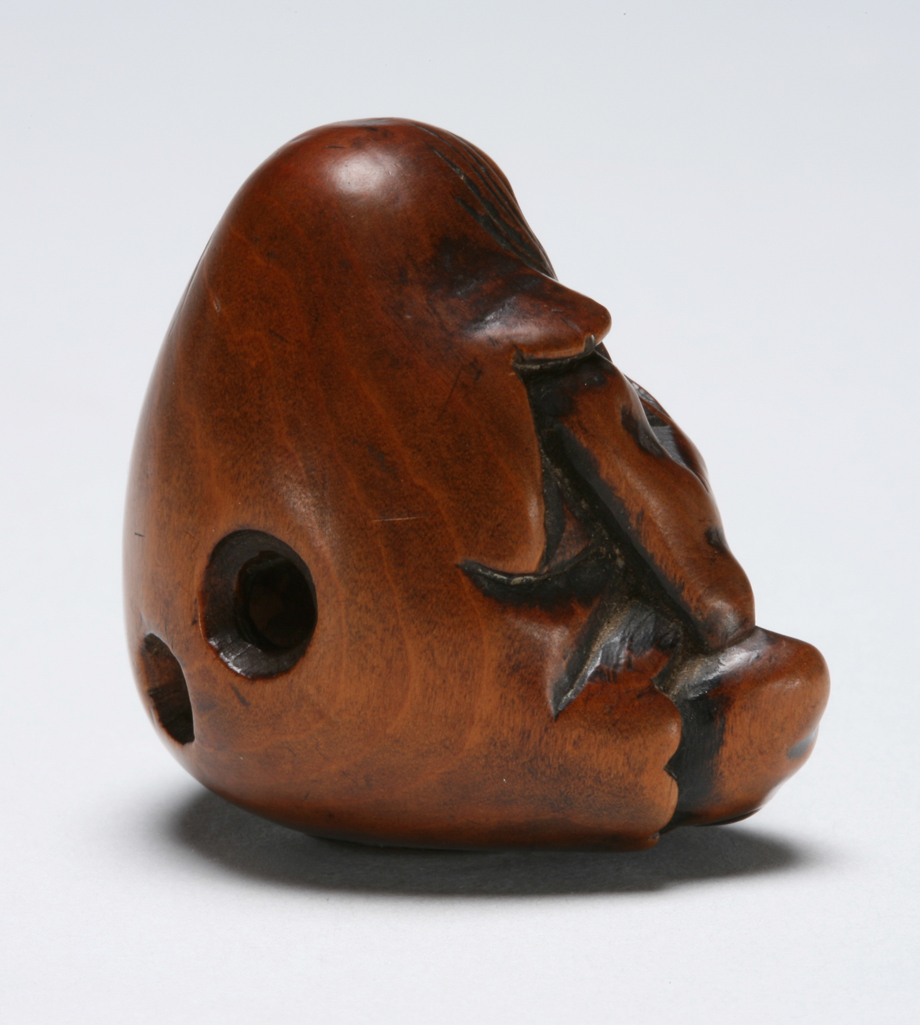 An image of Netsuke. Unknown maker, Japan. A seated Daruma. Boxwood, carved, 1800-1830.