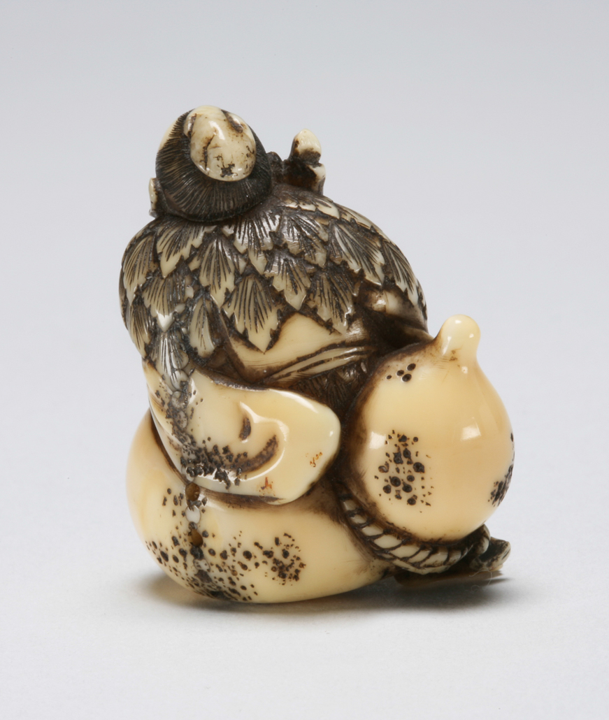 An image of Netsuke: katabori: Sennin Tekkai. Chogetsu, Edo Period (1603-1868). Figure of Sennin Tekkai as an old beggar holding a staff in his right hand, barefoot and wearing a cloak made of leaves revealing his ribs, blowing his spirit into space through his open mouth. He is seated on a gourd. The details are finely carved and incised. Himotoshi on the underside. Ivory, carved, incised and stained, height, whole, 4.0 cm, width, whole, 3.5 cm, circa 1800-1868. Edo Period (1615-1868).