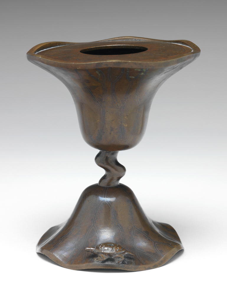 An image of Bronze candlestick, inlaid with silver, in the shape of a lotus leaf with a wavy edge. possibly Korean. 1600-1799.