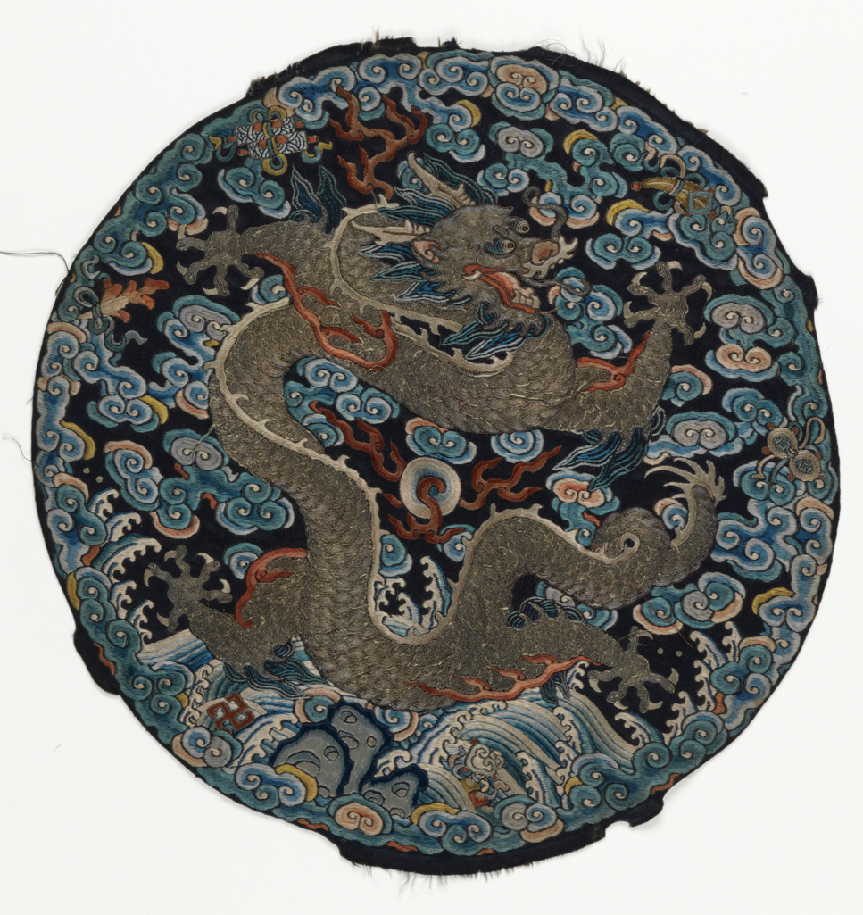 An image of Textiles. Roundel. Unknown maker, China. Five-clawed dragon on a background of waves and clouds, with six precious objects around perimeter. Silk and metal embroidery on satin; blue ground with polychrome embroidery - satin stitch, stem stitch, encroaching satin, seed stitch (Peking knot), with laid and couched work. Diameter, whole, 28 cm, circa 1750-circa 1775. Acquisition Credit: Given by Mrs. Soame Jenyns, in accordance with the wishes of her late husband, Soame Jenyns.